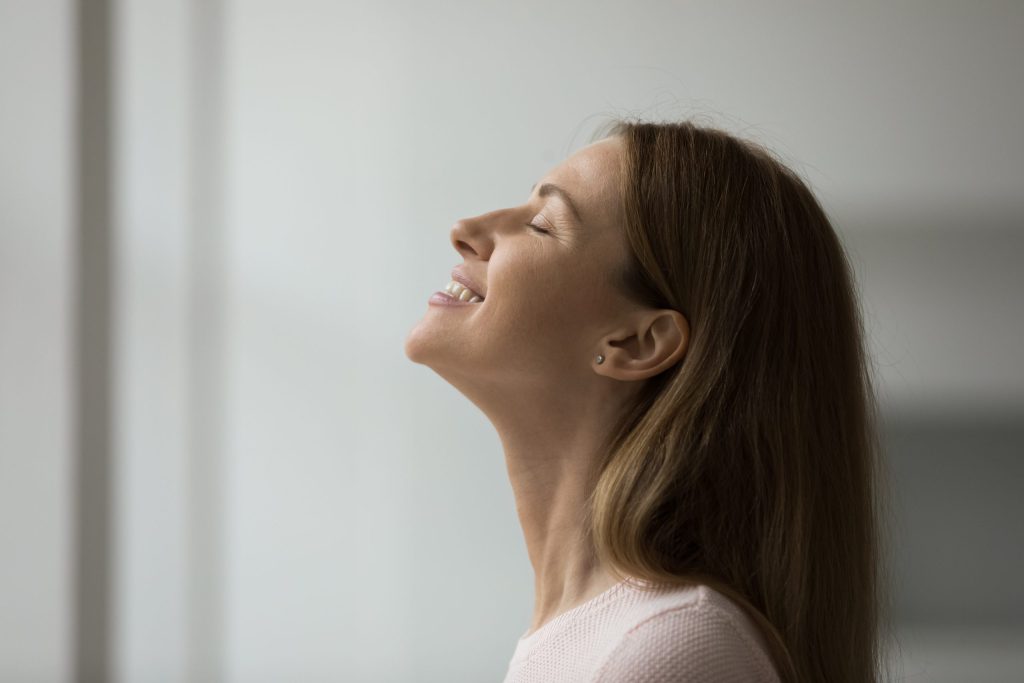 Side face view of beautiful woman enjoy pleasant fragrance